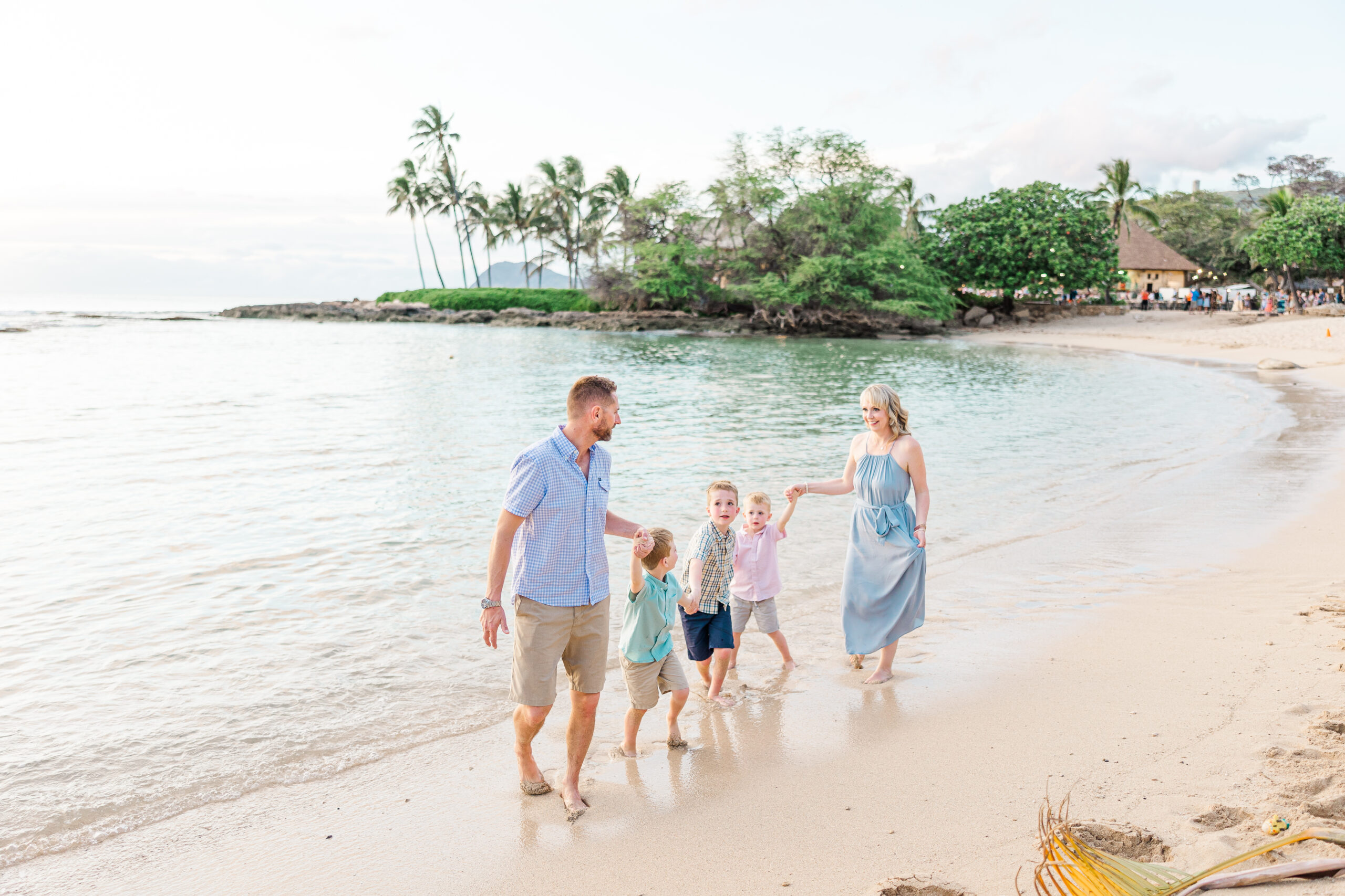 a family of 5 playing follow the leader on the beach during their Aulani mini session