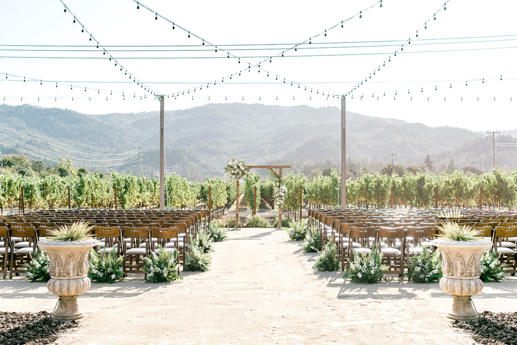 california wedding venue tre posti features a ceremony set up with a vineyard backdrop and the rolling hills of wine country